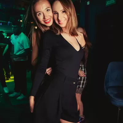 dwie dziewczyny pozują w klubie do zdjęcia